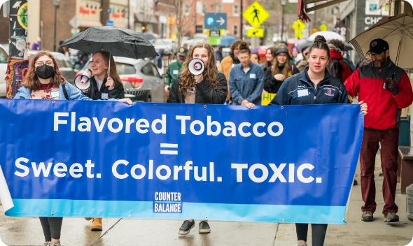 Women holding a sign against flavored tobacco