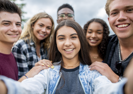 Teens taking a group selfie.